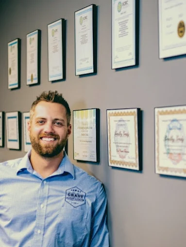 Bradley Grady, Owner and Managing Member of Grady Property Restoration, standing in front of professional restoration credentials.